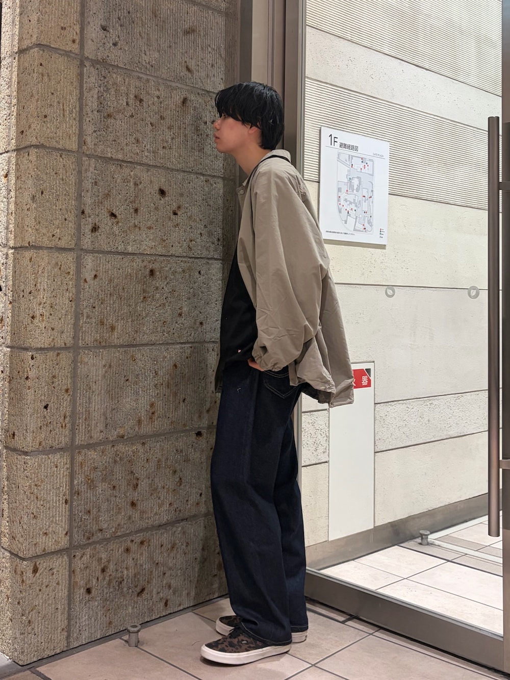 グリーン系のブルゾン、ブラック系のTシャツ/カットソー、ブルー系のデニムパンツを着用したメンズの春コーディネートの3枚目の写真