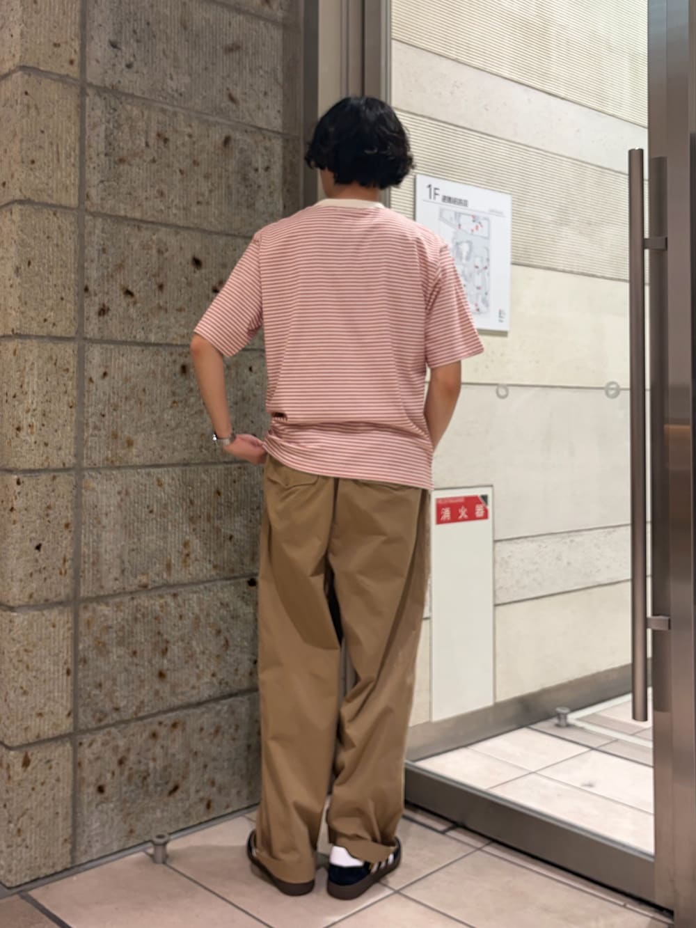 レッド系のTシャツ/カットソー、ベージュ系のその他パンツ、ブラック系のスニーカーを着用したメンズの春コーディネートの4枚目の写真