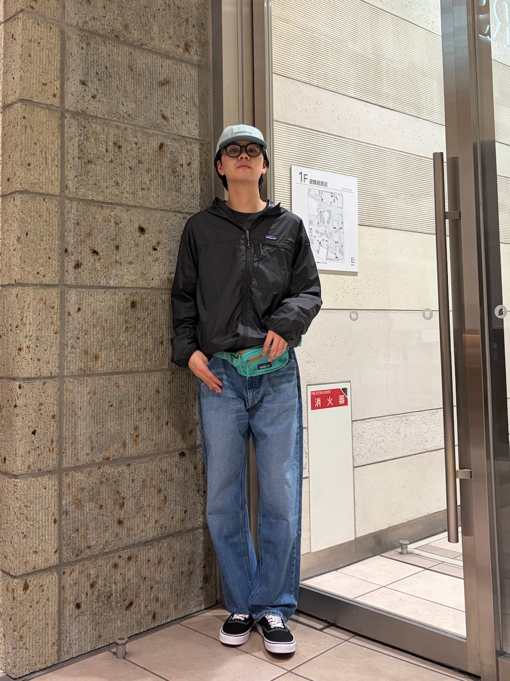 グレー系のTシャツ/カットソー、ブルー系のデニムパンツ、ブラック系のスニーカーを着用したメンズの春コーディネートの2枚目の写真