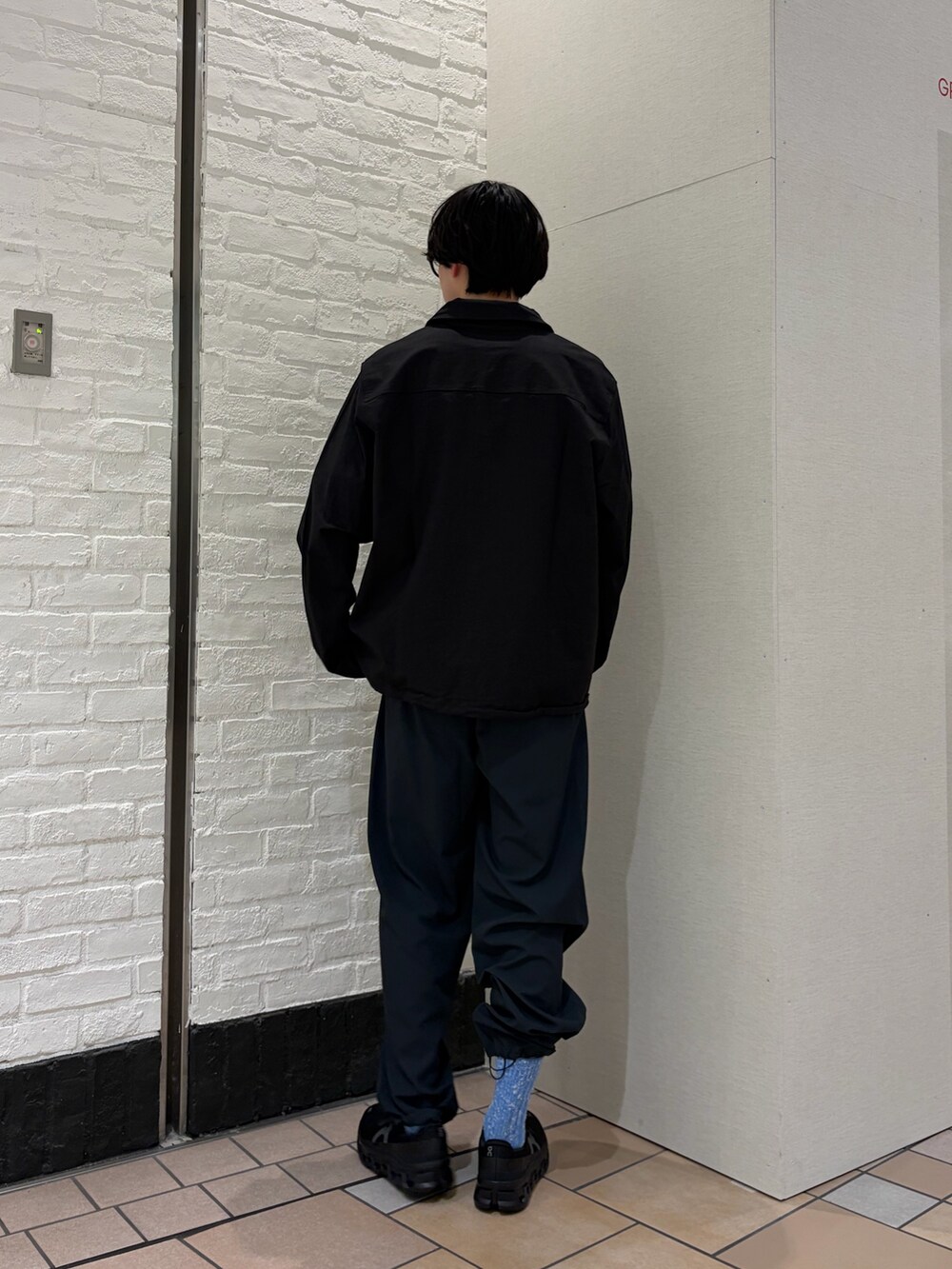 ブラック系のカバーオール、ブルー系のTシャツ/カットソー、ブラック系のスニーカーを着用したメンズの春コーディネートの4枚目の写真