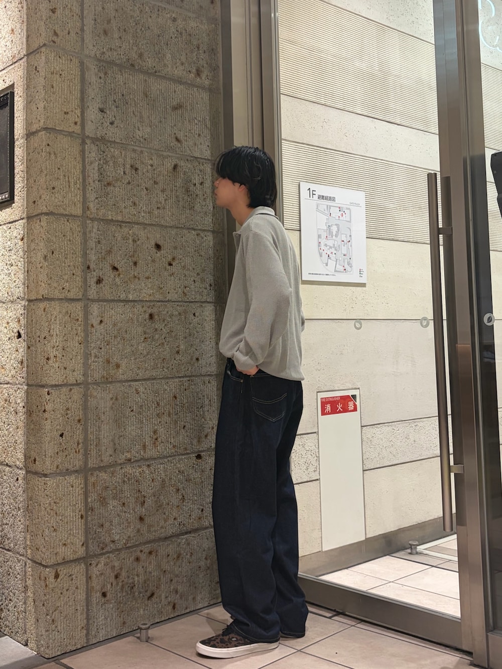 グレー系のニット/セーター、ブルー系のデニムパンツ、ブラウン系のスニーカーを着用したメンズの冬コーディネートの2枚目の写真