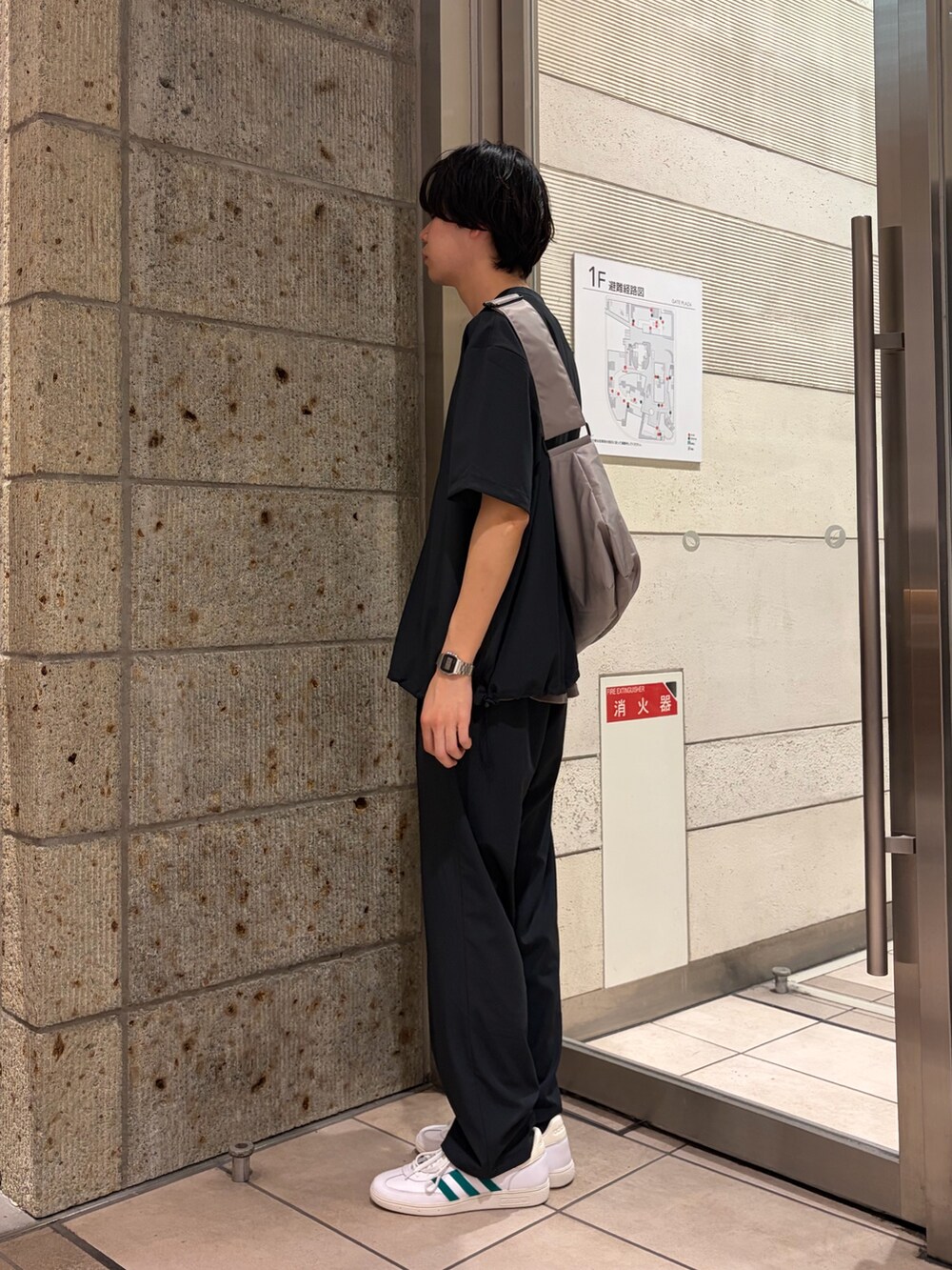 グレー系のTシャツ/カットソー、グレー系のショルダーバッグ、ブラック系のその他パンツを着用したメンズの春コーディネートの2枚目の写真