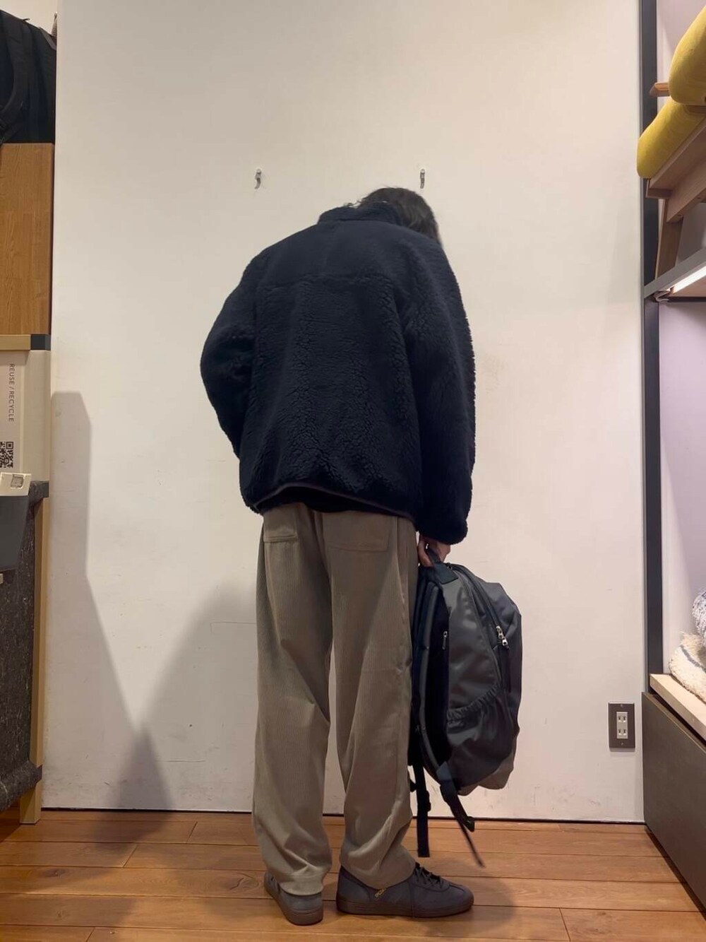 ブルー系のバックパック/リュック、ベージュ系のその他パンツ、ブラック系のテーラードジャケットを着用したメンズの冬コーディネートの3枚目の写真