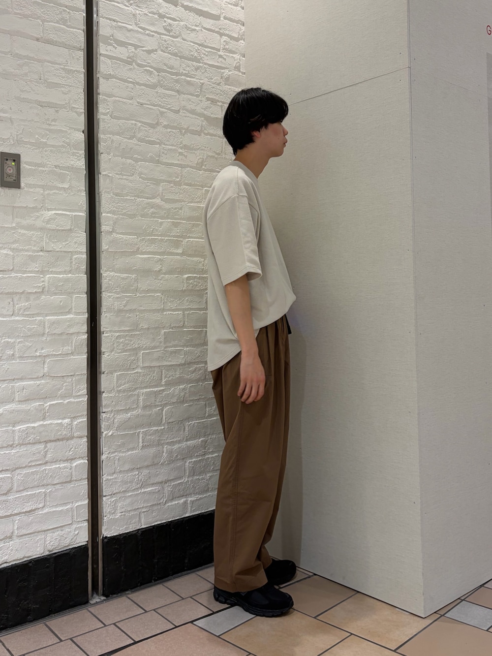 ホワイト系のTシャツ/カットソー、ブラウン系のその他パンツ、ブラック系のスニーカーを着用したメンズの春コーディネートの5枚目の写真