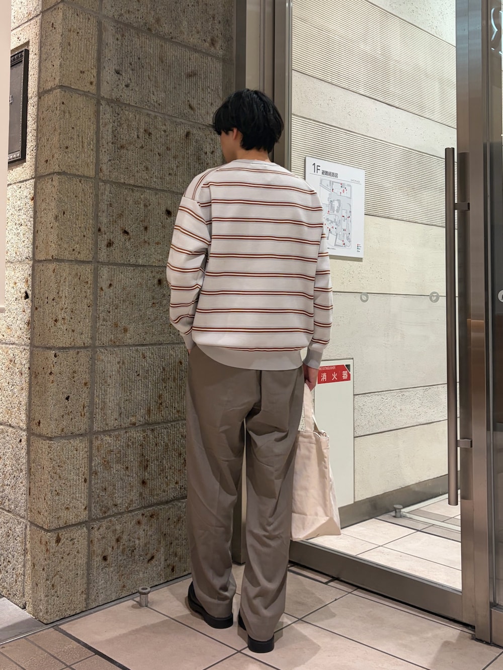 グレー系のニット/セーター、ベージュ系のその他パンツ、ベージュ系のショルダーバッグを着用したメンズの冬コーディネートの3枚目の写真