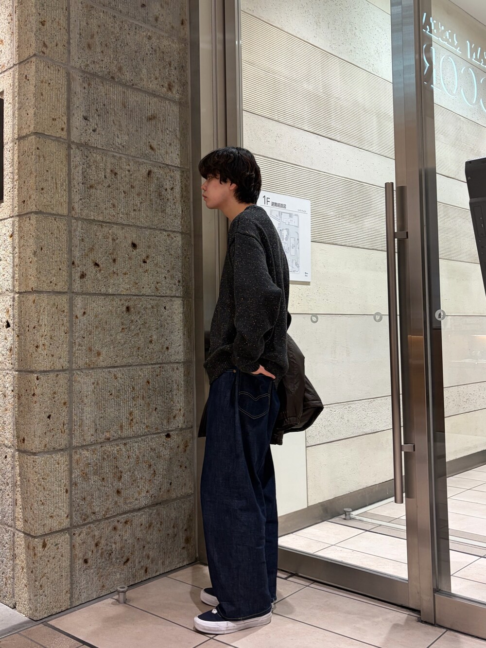 グレー系のニット/セーター、ブラウン系のブルゾン、ブルー系のデニムパンツを着用したメンズの冬コーディネートの4枚目の写真