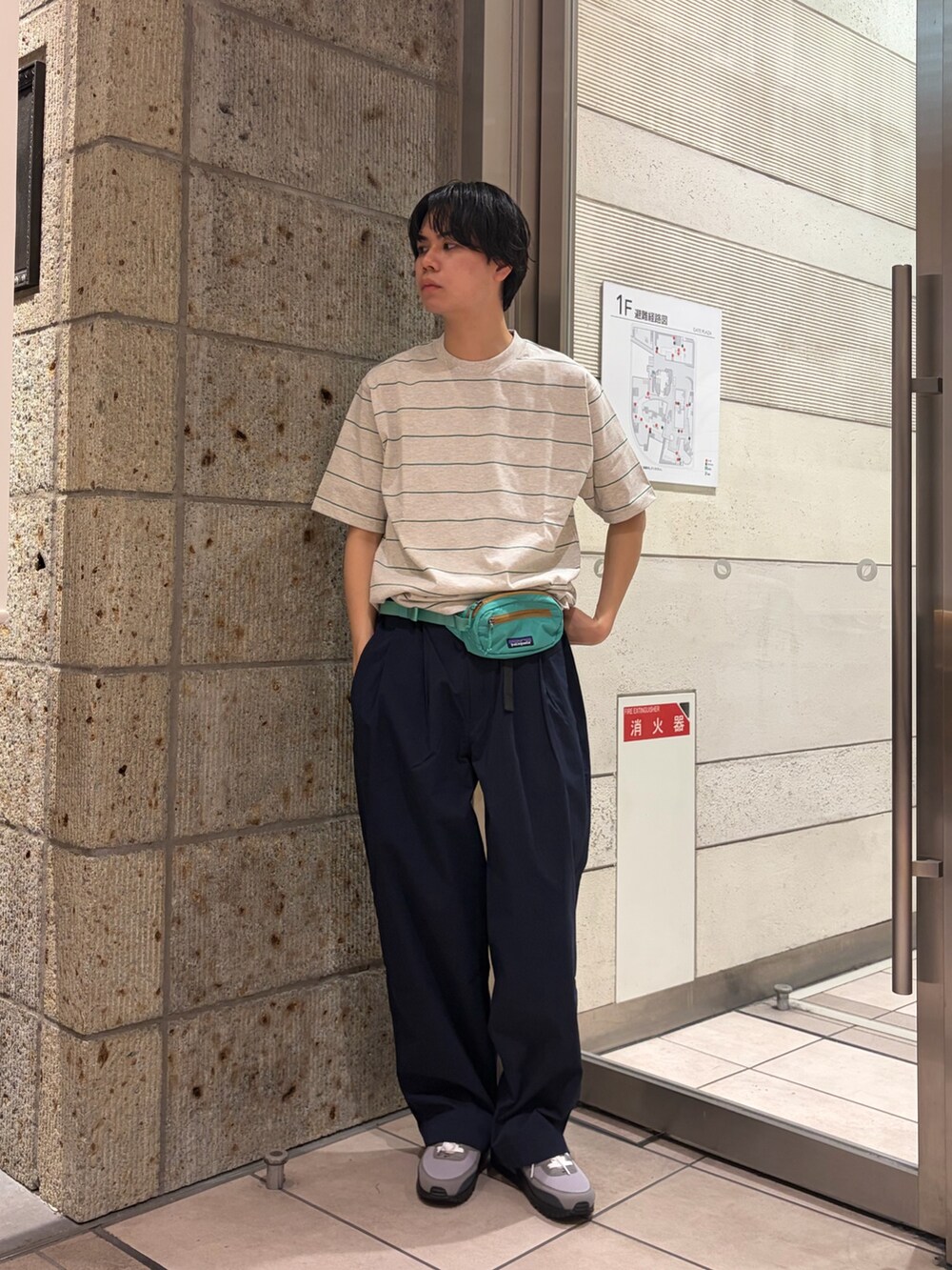 ブラック系のナイロンジャケット、ブルー系のその他パンツ、グリーン系のTシャツ/カットソーを着用したメンズの春コーディネートの4枚目の写真