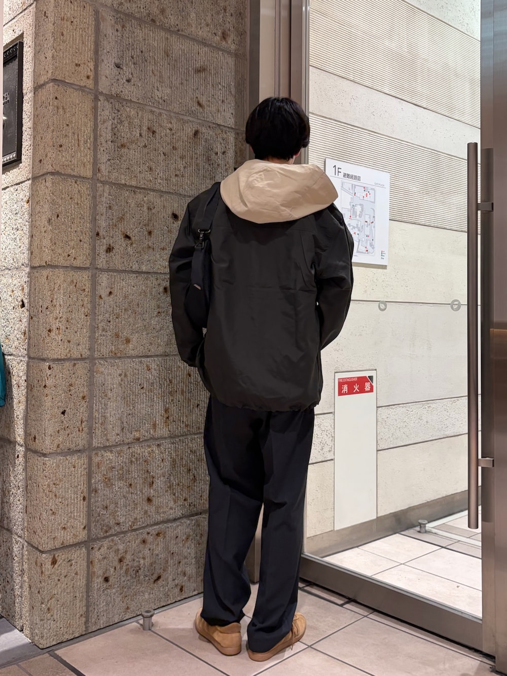 ベージュ系のマウンテンパーカー、ブラック系のその他アウター、ホワイト系のTシャツ/カットソーを着用したメンズの春コーディネートの4枚目の写真