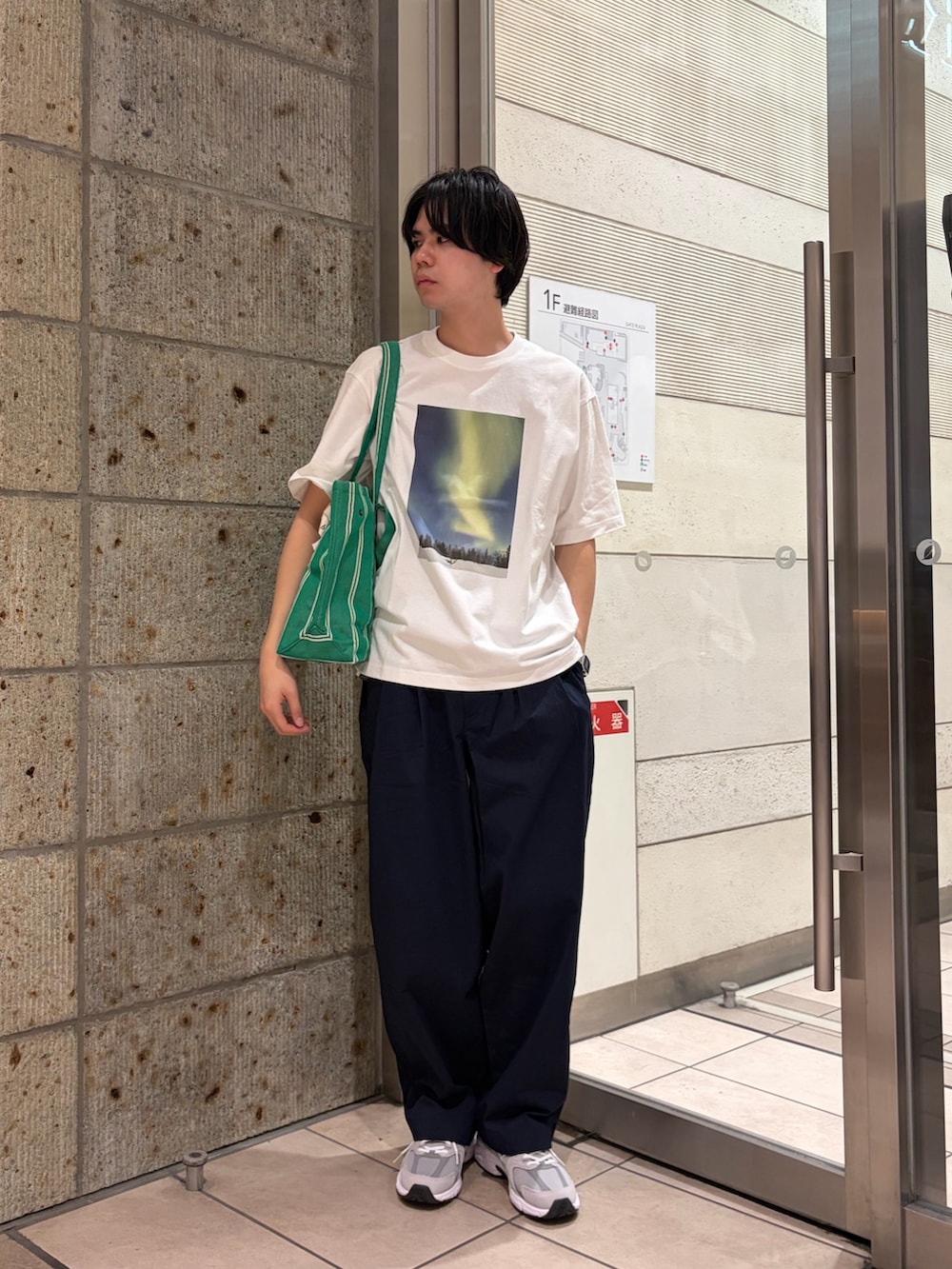 グリーン系のトートバッグ、グレー系のスニーカー、ブルー系のその他パンツを着用したメンズの春コーディネートの4枚目の写真