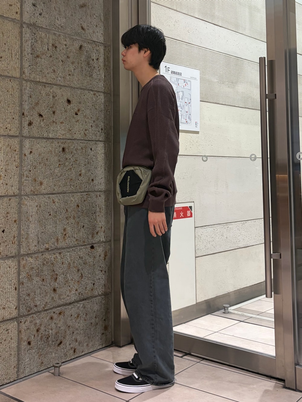 ブラウン系のTシャツ/カットソー、グリーン系のボディバッグ/ウエストポーチ、ブルー系のデニムパンツを着用したメンズの夏コーディネートの3枚目の写真