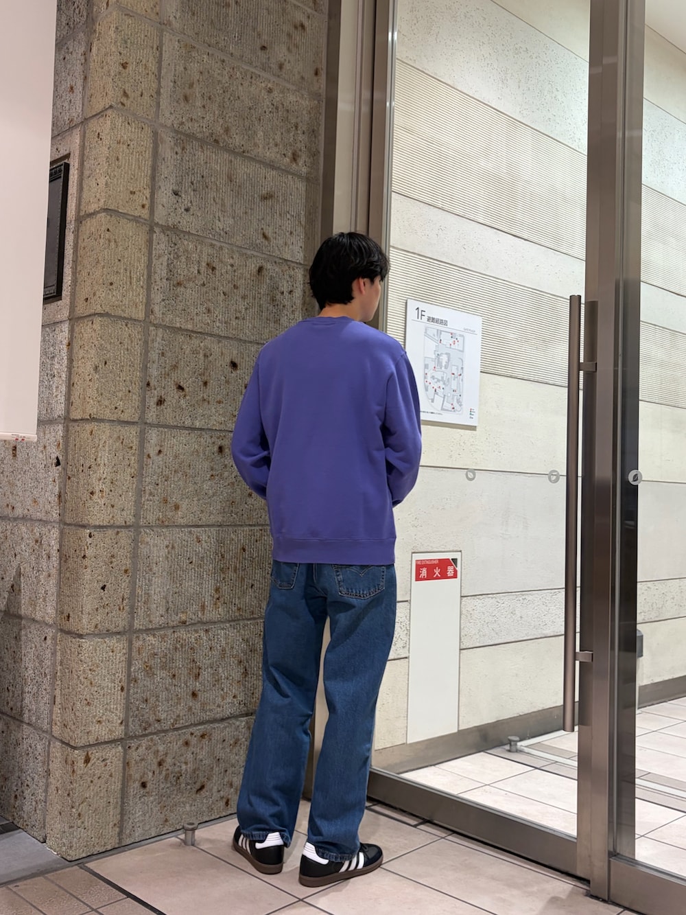 ブルー系のスウェット、ブラック系のスニーカー、ブルー系のデニムパンツを着用したメンズの冬コーディネートの3枚目の写真