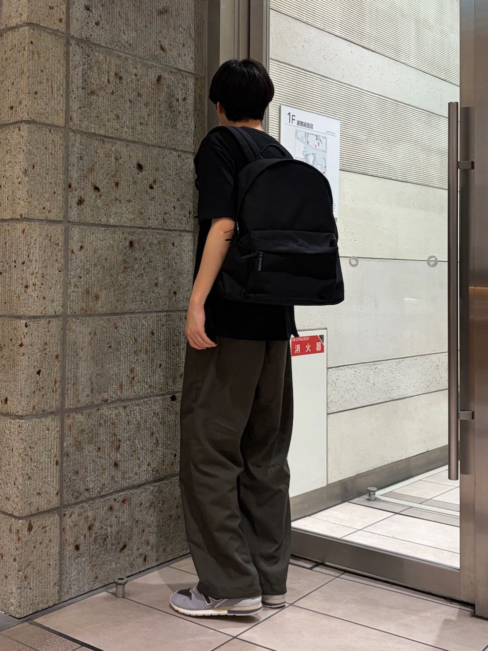 ブラック系のTシャツ/カットソー、グリーン系のその他パンツ、ブラック系のバックパック/リュックを着用したメンズの夏コーディネートの4枚目の写真
