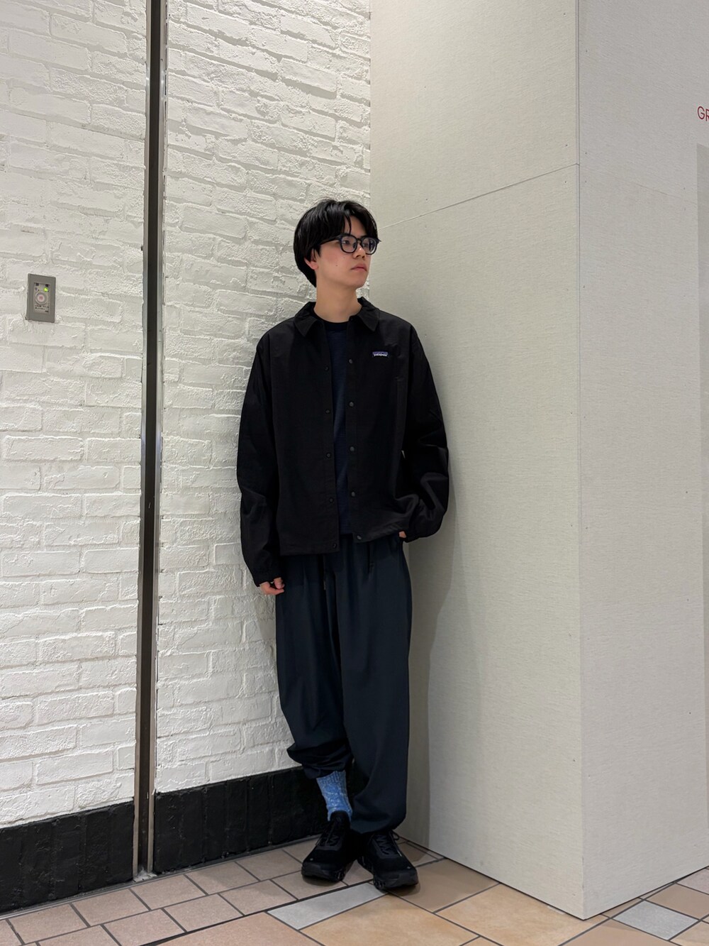 ブラック系のカバーオール、ブルー系のTシャツ/カットソー、ブラック系のスニーカーを着用したメンズの春コーディネートの6枚目の写真