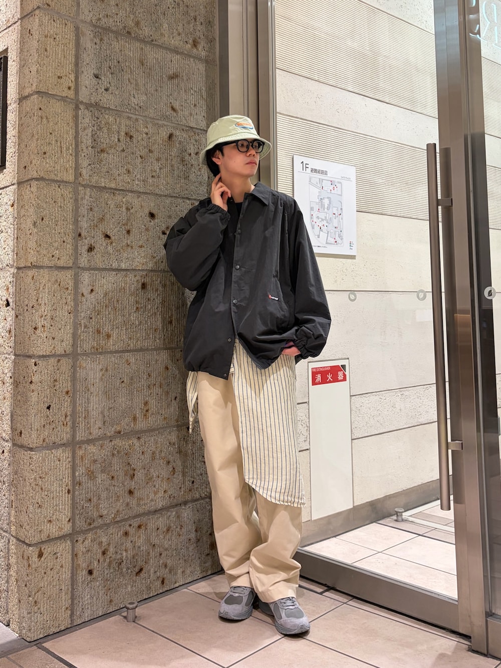 ブラック系のブルゾン、ブルー系のニット/セーター、イエロー系のシャツ/ブラウスを着用したメンズの春コーディネートの2枚目の写真