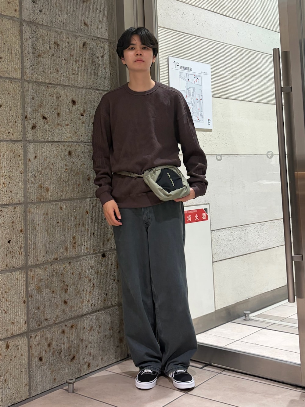 ブラウン系のTシャツ/カットソー、グリーン系のボディバッグ/ウエストポーチ、ブルー系のデニムパンツを着用したメンズの夏コーディネートの2枚目の写真