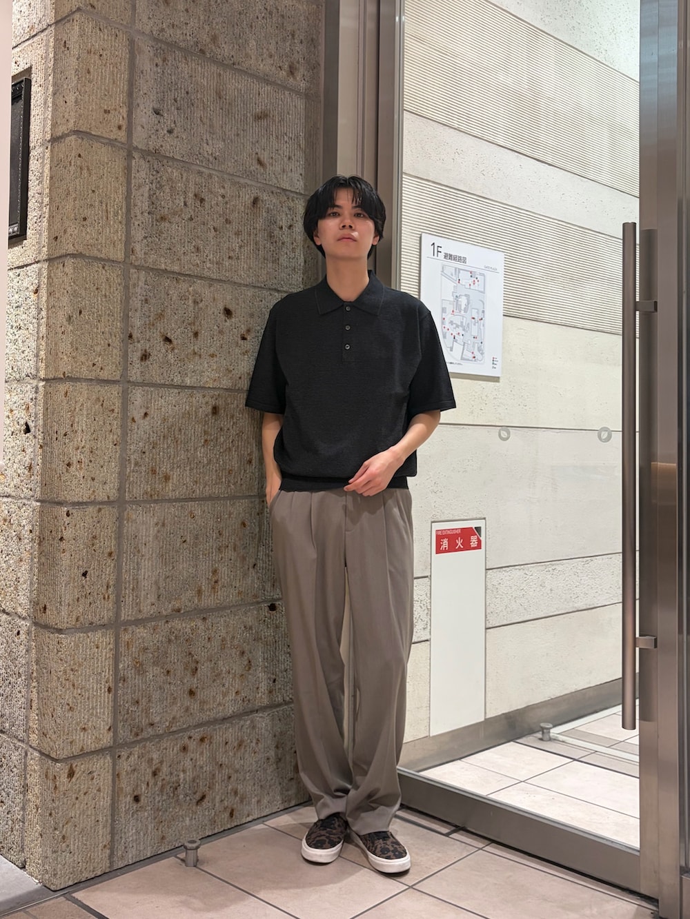 グレー系のニット/セーター、ベージュ系のその他パンツ、ブラウン系のスニーカーを着用したメンズの春コーディネートの2枚目の写真