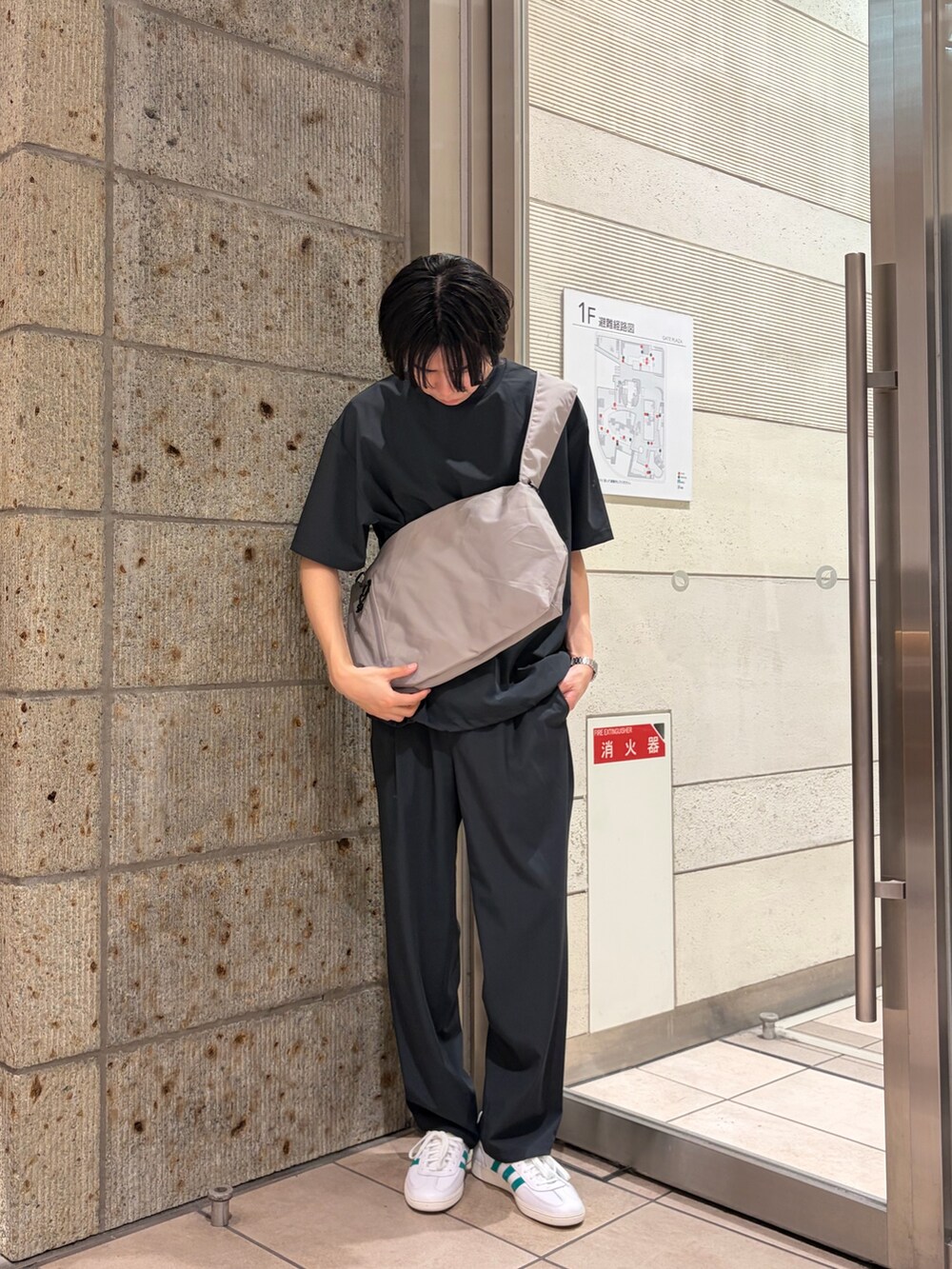グレー系のTシャツ/カットソー、グレー系のショルダーバッグ、ブラック系のその他パンツを着用したメンズの春コーディネートの4枚目の写真