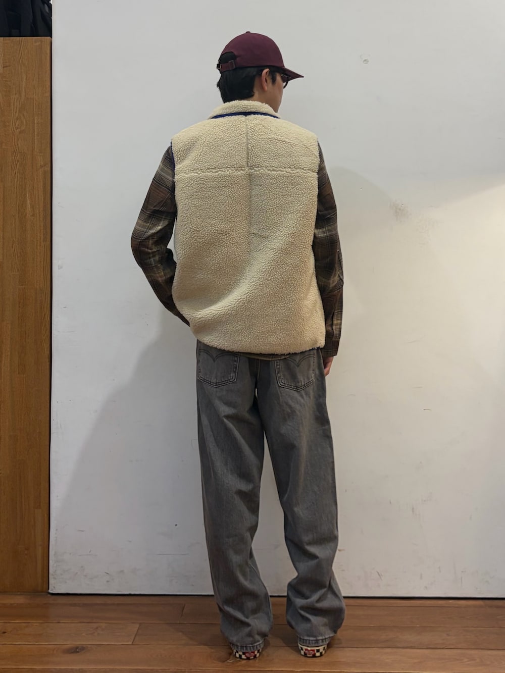ベージュ系のベスト、ブラウン系のシャツ/ブラウス、ブラック系のデニムパンツを着用したメンズの秋コーディネートの3枚目の写真