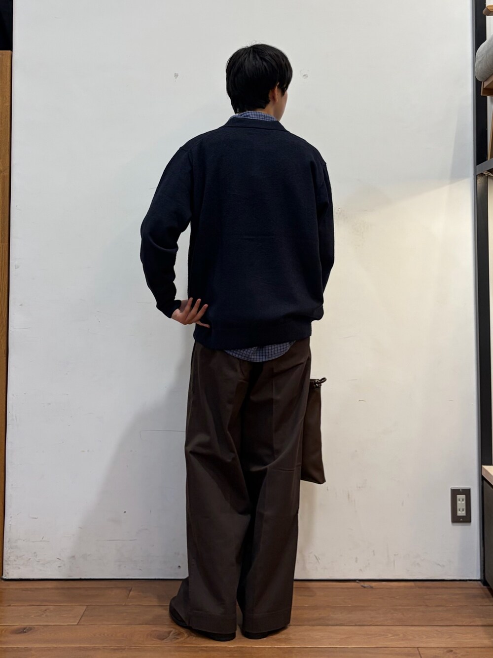 ブルー系のニット/セーター、ブラウン系のメッセンジャーバッグ、ブラウン系のその他パンツを着用したメンズの秋コーディネートの4枚目の写真