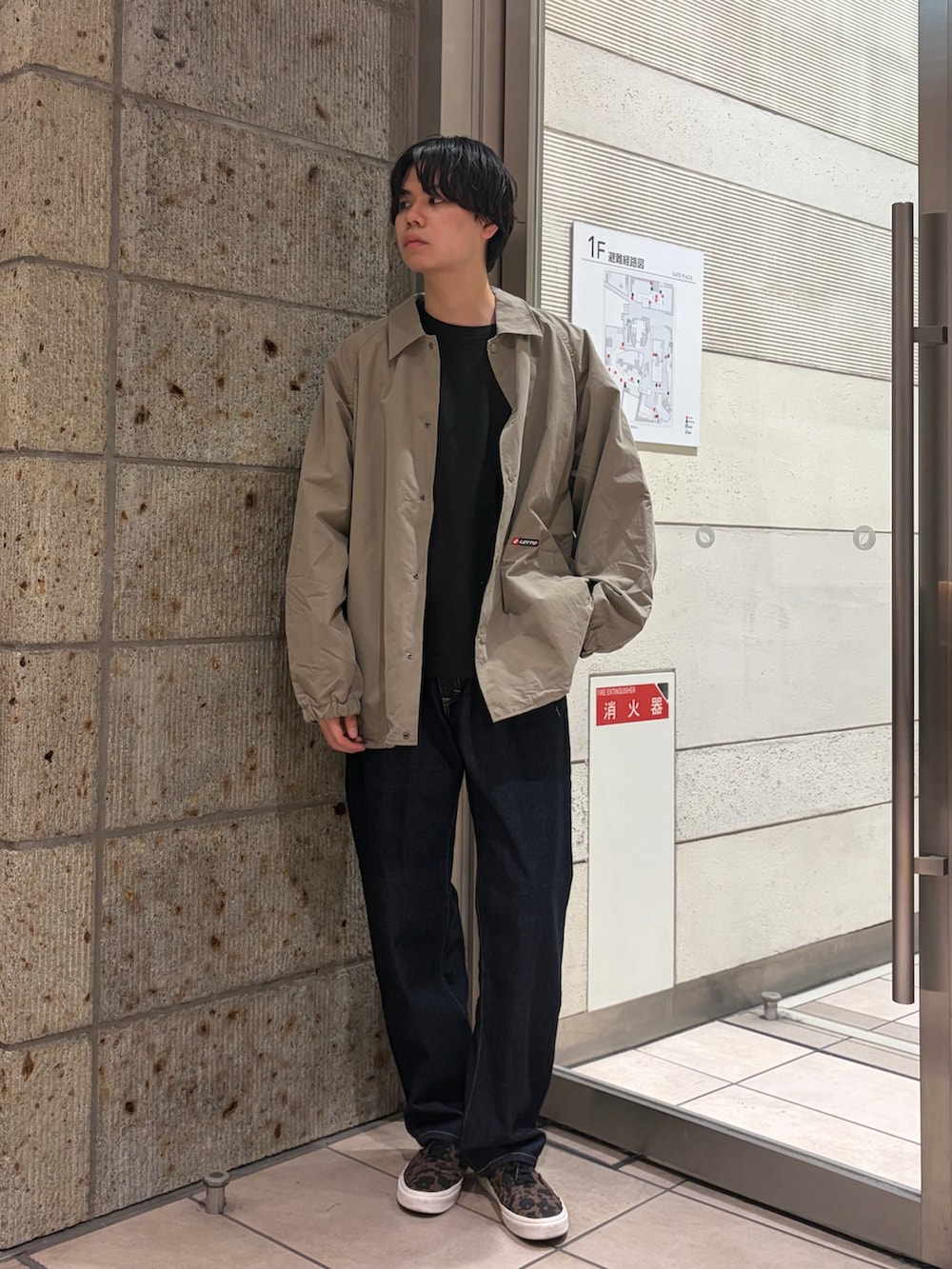 グリーン系のブルゾン、ブラック系のTシャツ/カットソー、ブルー系のデニムパンツを着用したメンズの春コーディネートの2枚目の写真