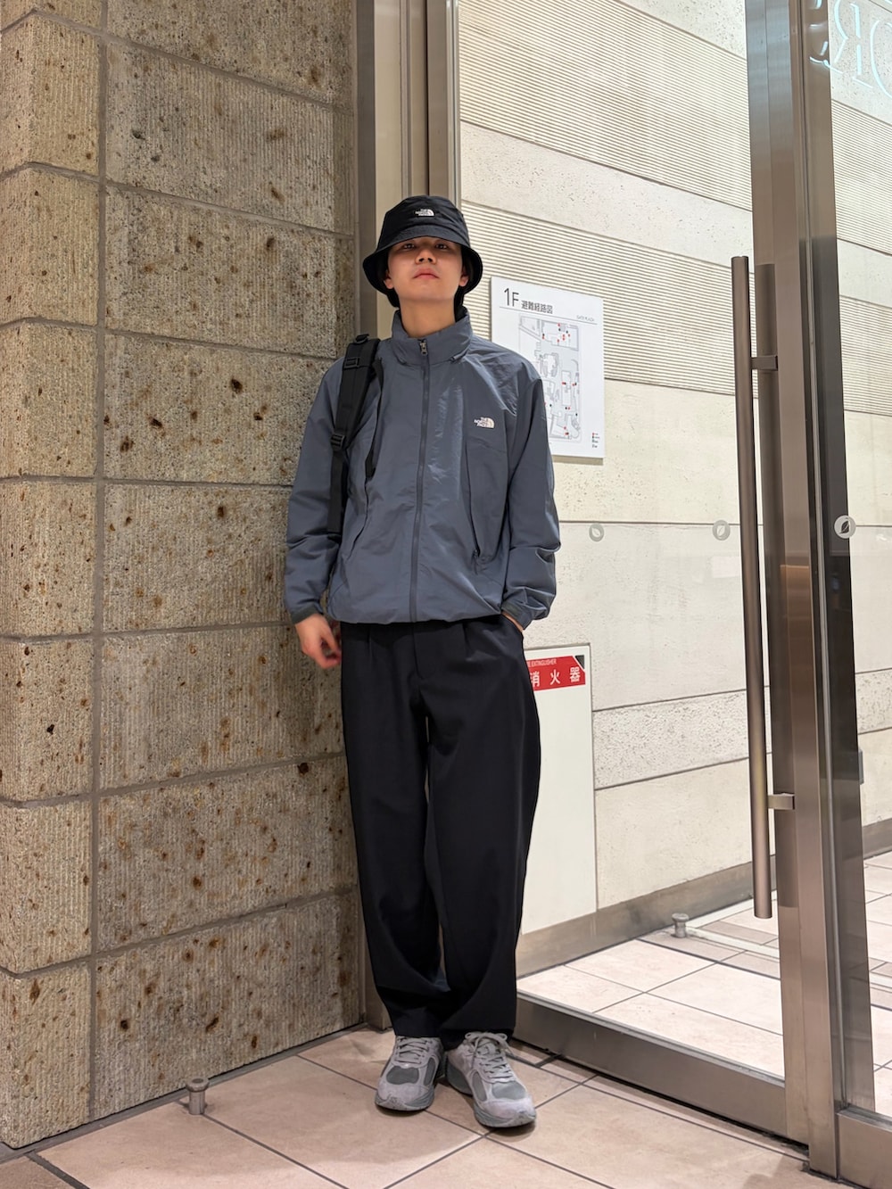 グレー系のブルゾン、ブルー系のその他パンツ、ブラック系のバックパック/リュックを着用したメンズの春コーディネートの2枚目の写真