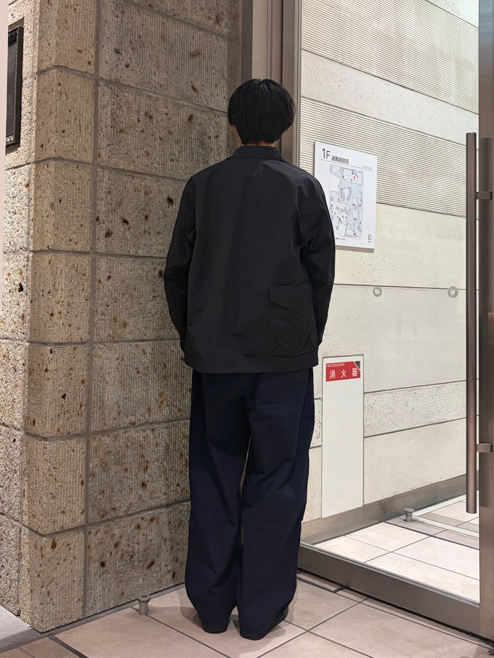 ブラック系のナイロンジャケット、ブルー系のその他パンツ、グリーン系のTシャツ/カットソーを着用したメンズの春コーディネートの3枚目の写真