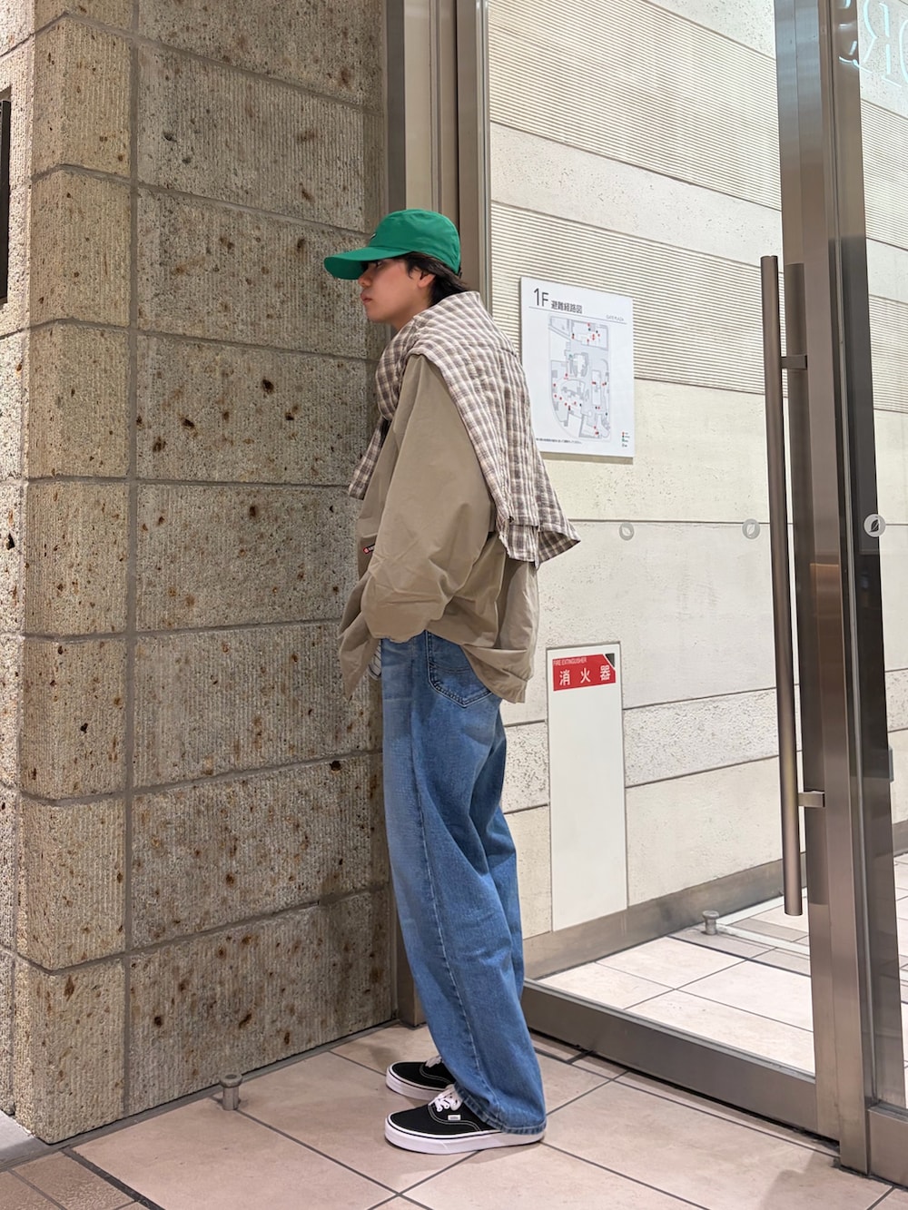 ベージュ系のその他アウター、グリーン系のブルゾン、ホワイト系のTシャツ/カットソーを着用したメンズの春コーディネートの4枚目の写真