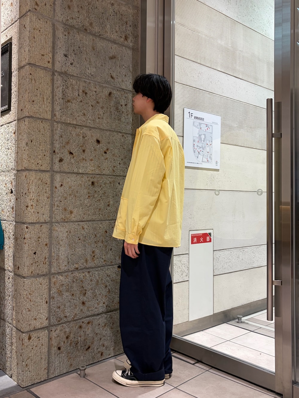 ブラック系のスニーカー、イエロー系のカバーオール、ブルー系のその他パンツを着用したメンズの春コーディネートの3枚目の写真