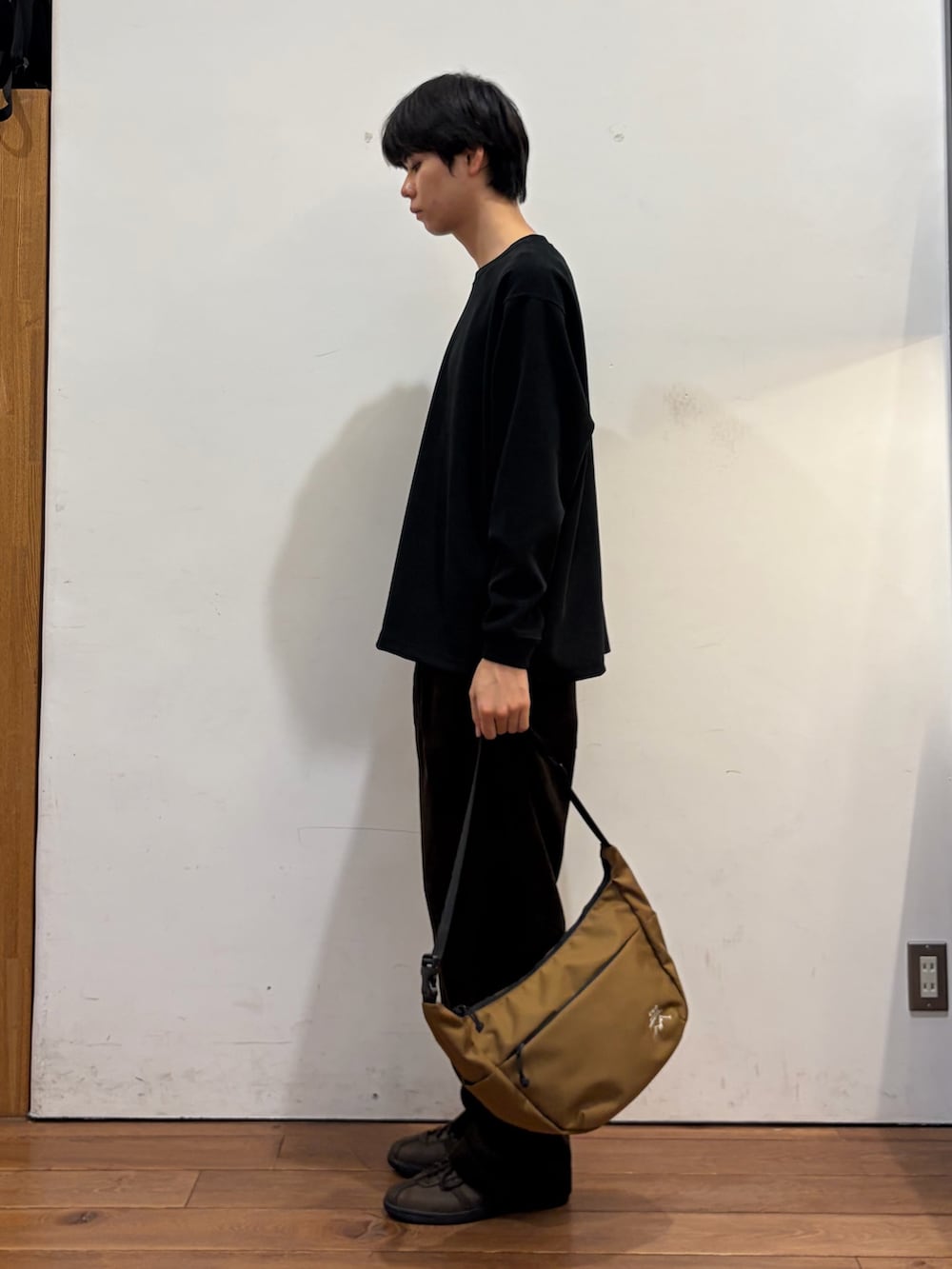 ブラック系のTシャツ/カットソー、ブラウン系のその他パンツ、ブラウン系のショルダーバッグを着用したメンズの秋コーディネートの2枚目の写真