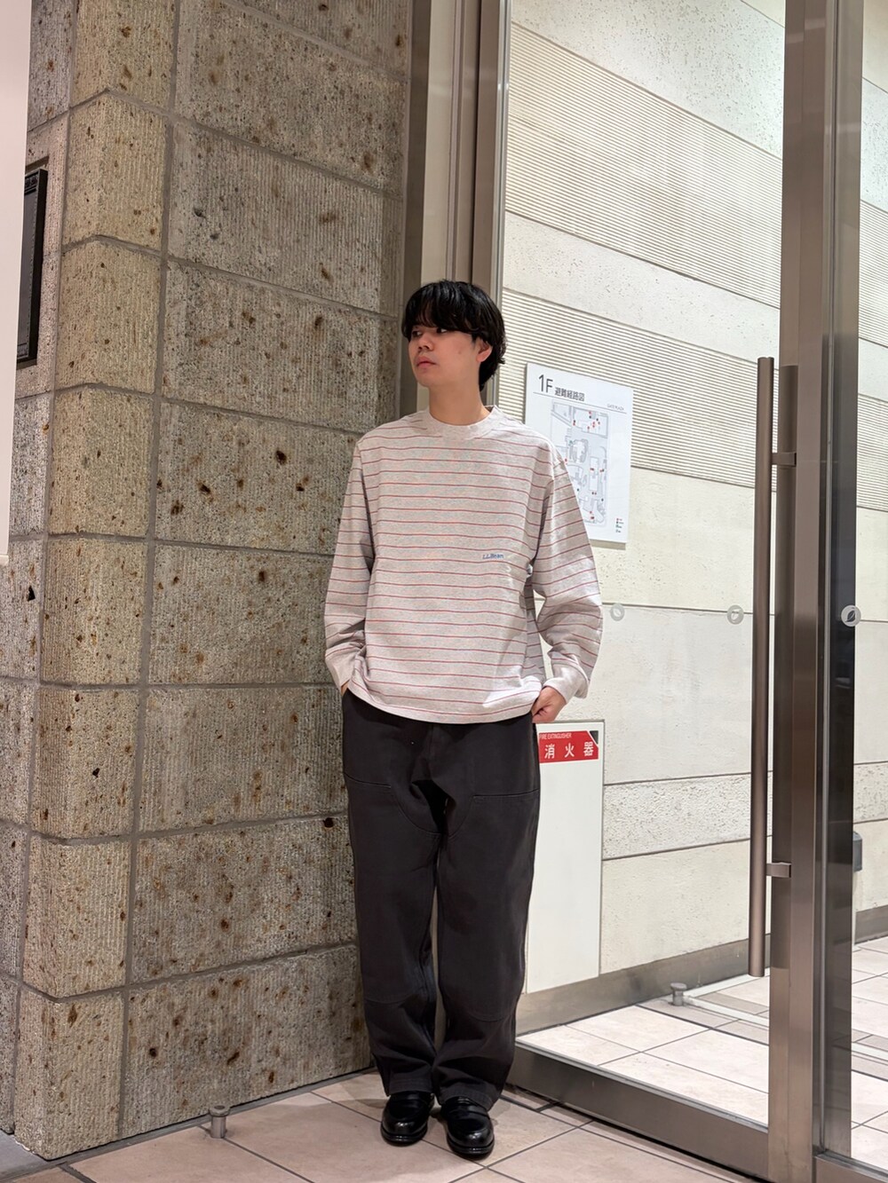 レッド系のTシャツ/カットソー、ブラック系のドレスシューズ、グレー系のその他パンツを着用したメンズの冬コーディネートの2枚目の写真