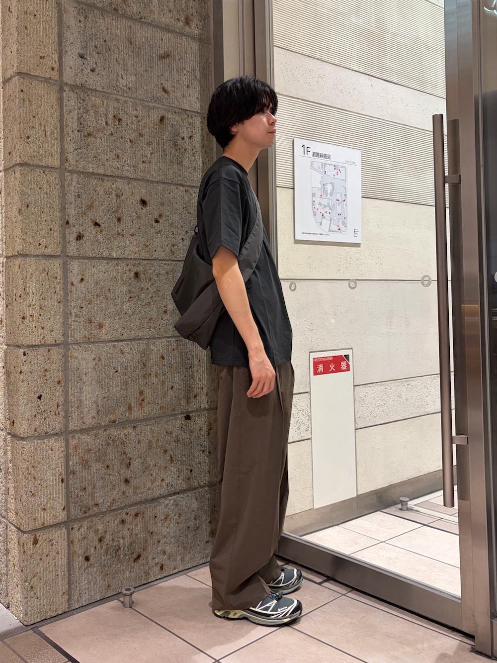 グレー系のTシャツ/カットソー、グレー系のショルダーバッグ、ブラック系のスニーカーを着用したメンズの春コーディネートの6枚目の写真
