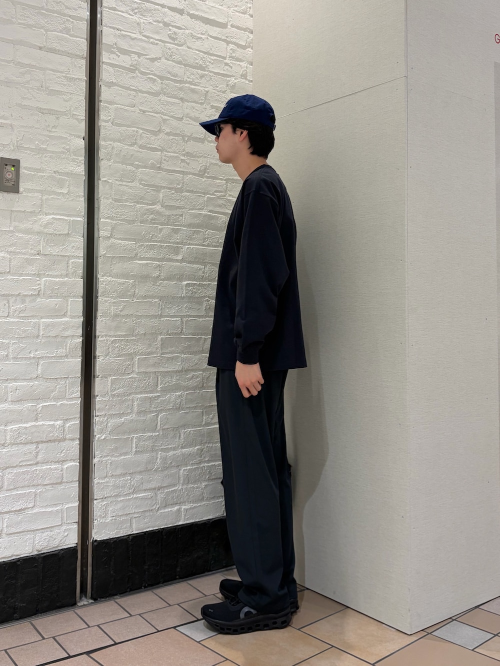 グレー系のTシャツ/カットソー、ブラック系のショルダーバッグ、ブラック系のスニーカーを着用したメンズの春コーディネートの3枚目の写真