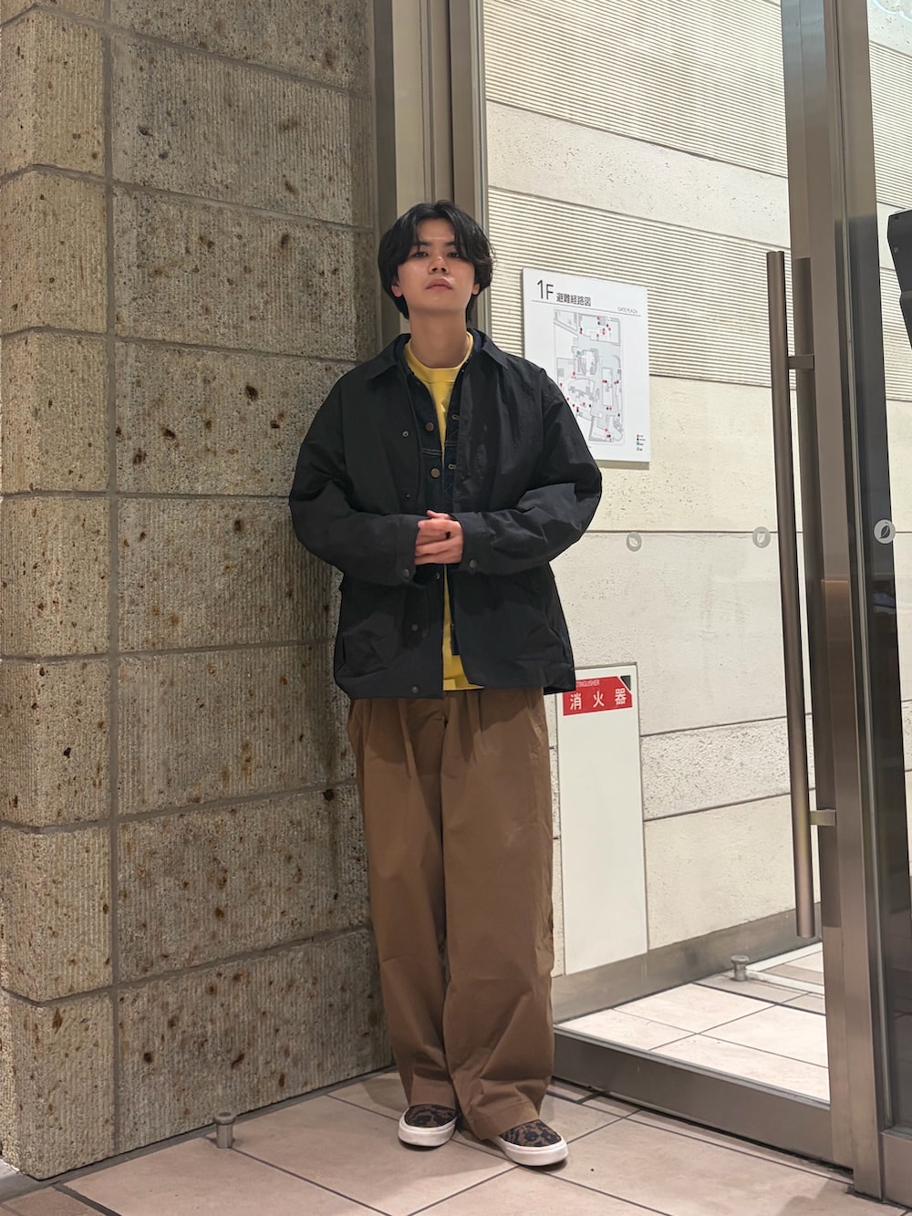 ブラック系のナイロンジャケット、ブルー系のデニムジャケット、イエロー系のTシャツ/カットソーを着用したメンズの春コーディネートの2枚目の写真