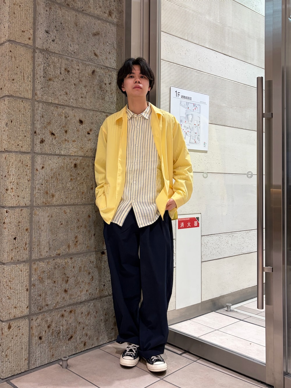ブラック系のスニーカー、イエロー系のカバーオール、ブルー系のその他パンツを着用したメンズの春コーディネートの2枚目の写真