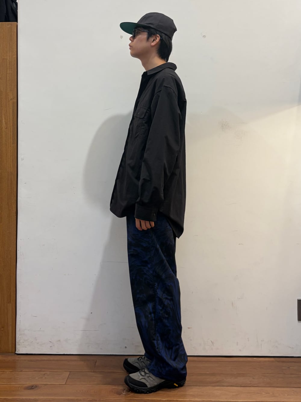 ブラック系のシャツ/ブラウス、ブルー系のその他パンツ、グレー系のスニーカーを着用したメンズの秋コーディネートの4枚目の写真