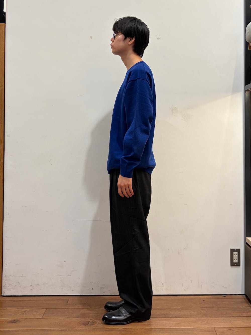 ブルー系のニット/セーター、その他のその他パンツ、ブラック系のドレスシューズを着用したメンズの秋コーディネートの4枚目の写真