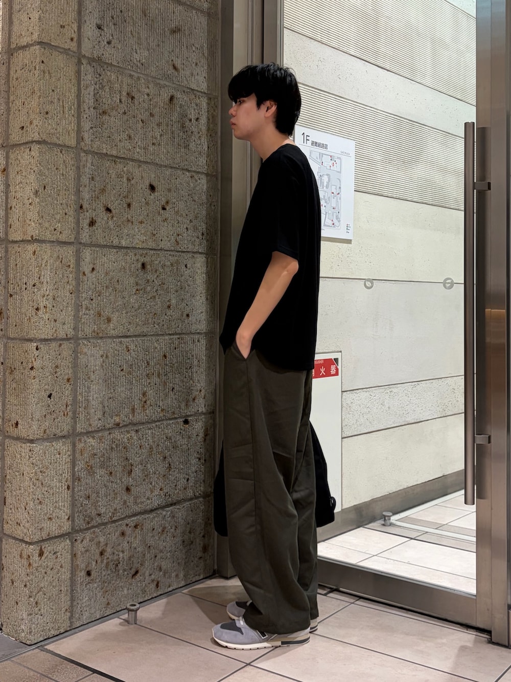 ブラック系のTシャツ/カットソー、グリーン系のその他パンツ、ブラック系のバックパック/リュックを着用したメンズの夏コーディネートの3枚目の写真