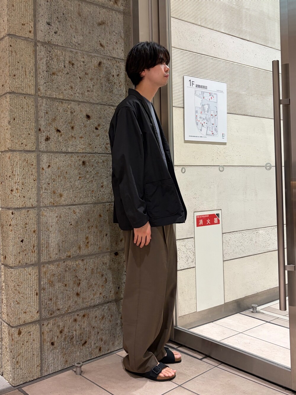 ブラック系のサンダル、ブルー系のTシャツ/カットソー、ブラック系のその他アウターを着用したメンズの春コーディネートの4枚目の写真