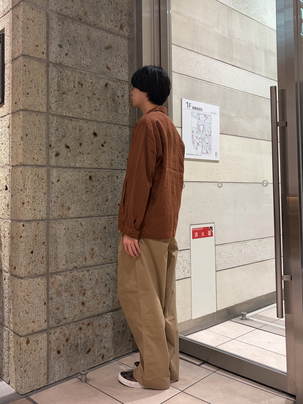 ブラウン系のその他アウター、ブラウン系のスニーカー、ベージュ系のTシャツ/カットソーを着用したメンズの春コーディネートの4枚目の写真