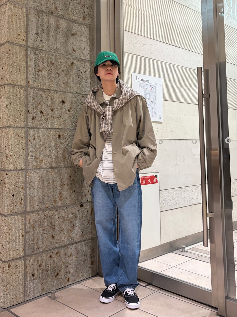 ベージュ系のその他アウター、グリーン系のブルゾン、ホワイト系のTシャツ/カットソーを着用したメンズの春コーディネートの3枚目の写真