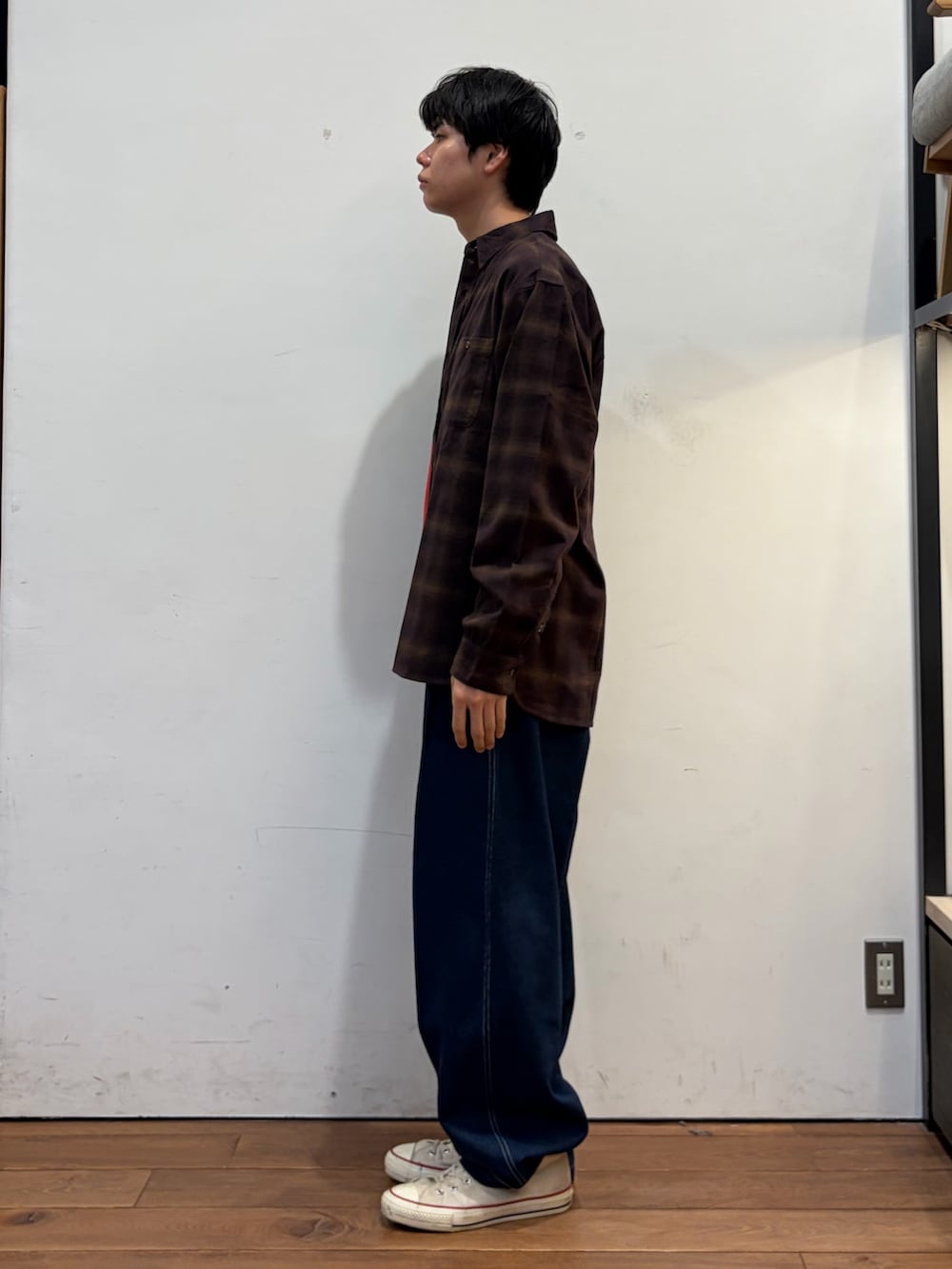 レッド系のニット/セーター、ブラウン系のシャツ/ブラウス、ブルー系のその他パンツを着用したメンズの秋コーディネートの2枚目の写真