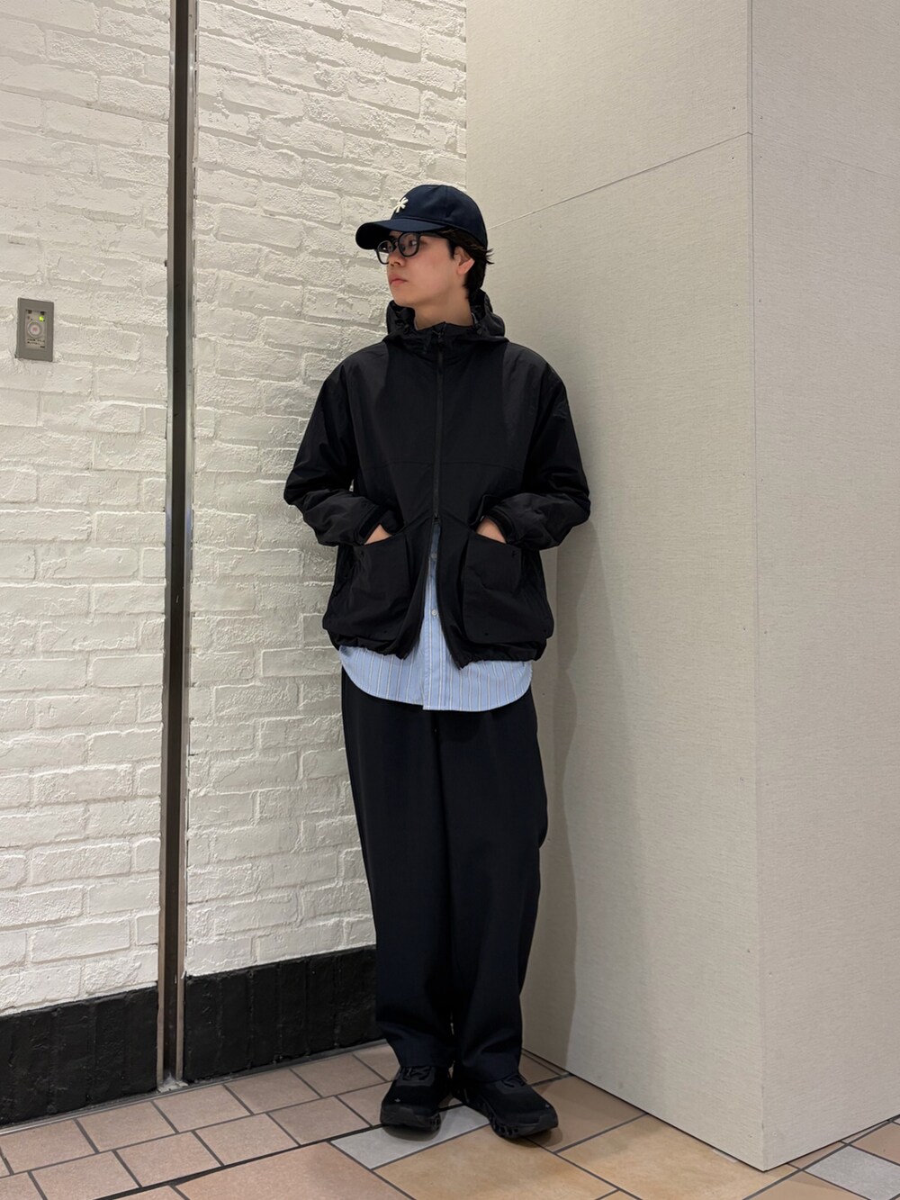 ブラック系のマウンテンパーカー、ブルー系のシャツ/ブラウス、ブルー系のその他パンツを着用したメンズの春コーディネートの3枚目の写真