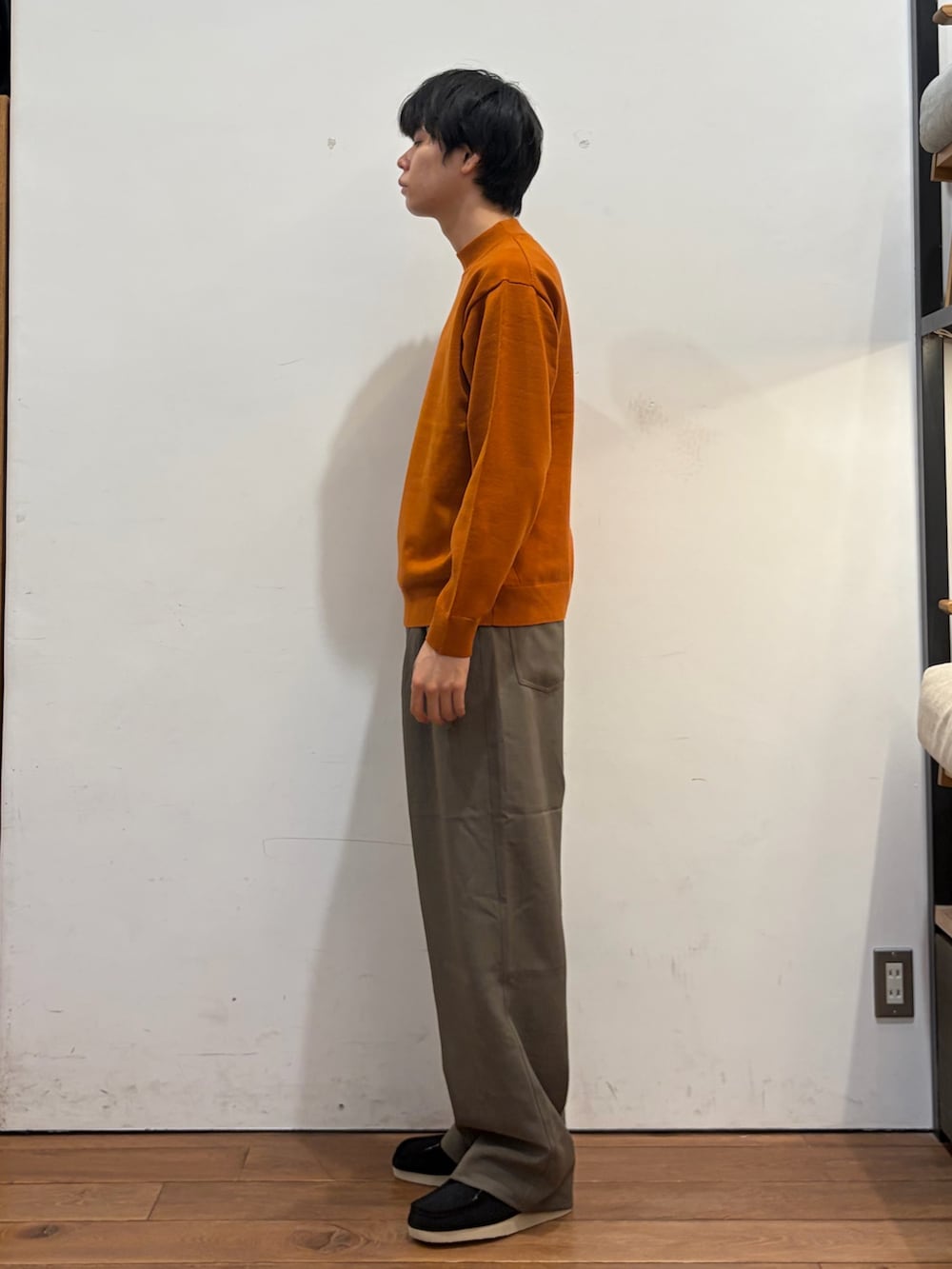 オレンジ系のニット/セーター、ベージュ系のその他パンツ、ブラック系のブーツを着用したメンズの秋コーディネートの3枚目の写真