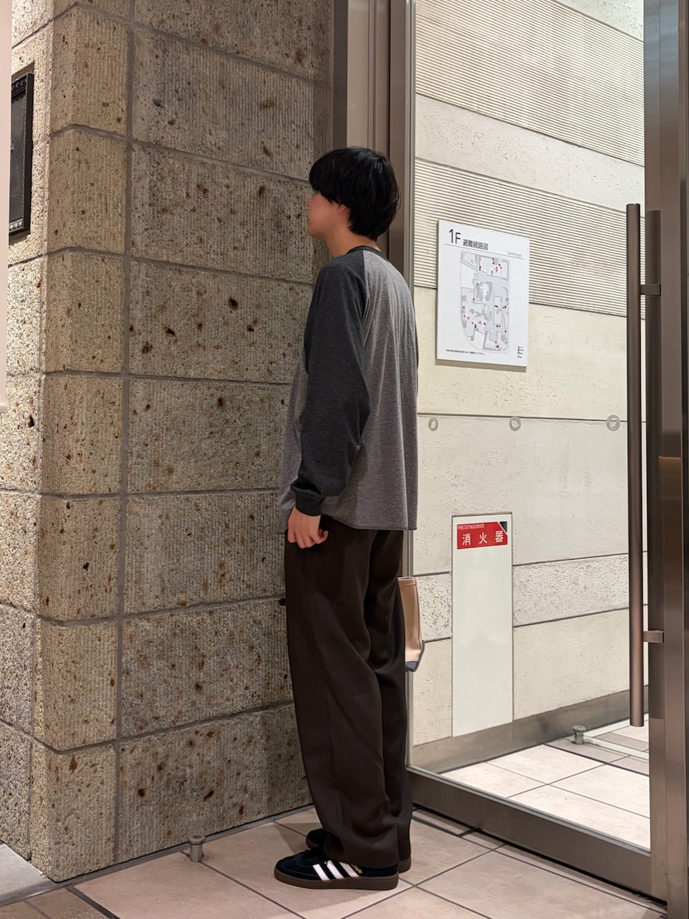 グレー系のTシャツ/カットソー、ブラウン系のその他パンツ、ブラック系のスニーカーを着用したメンズの春コーディネートの4枚目の写真