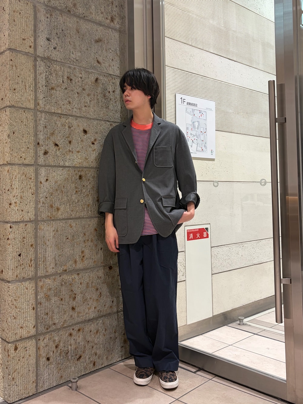 グレー系のその他アウター、グリーン系のTシャツ/カットソー、ブラウン系のスニーカーを着用したメンズの春コーディネートの2枚目の写真