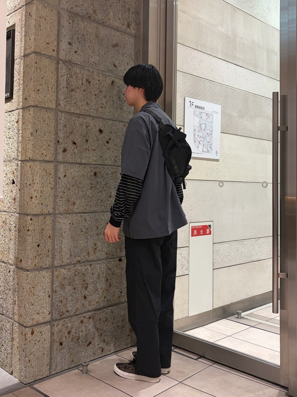 ブラウン系のスニーカー、グレー系のシャツ/ブラウス、ブラック系のショルダーバッグを着用したメンズの春コーディネートの3枚目の写真