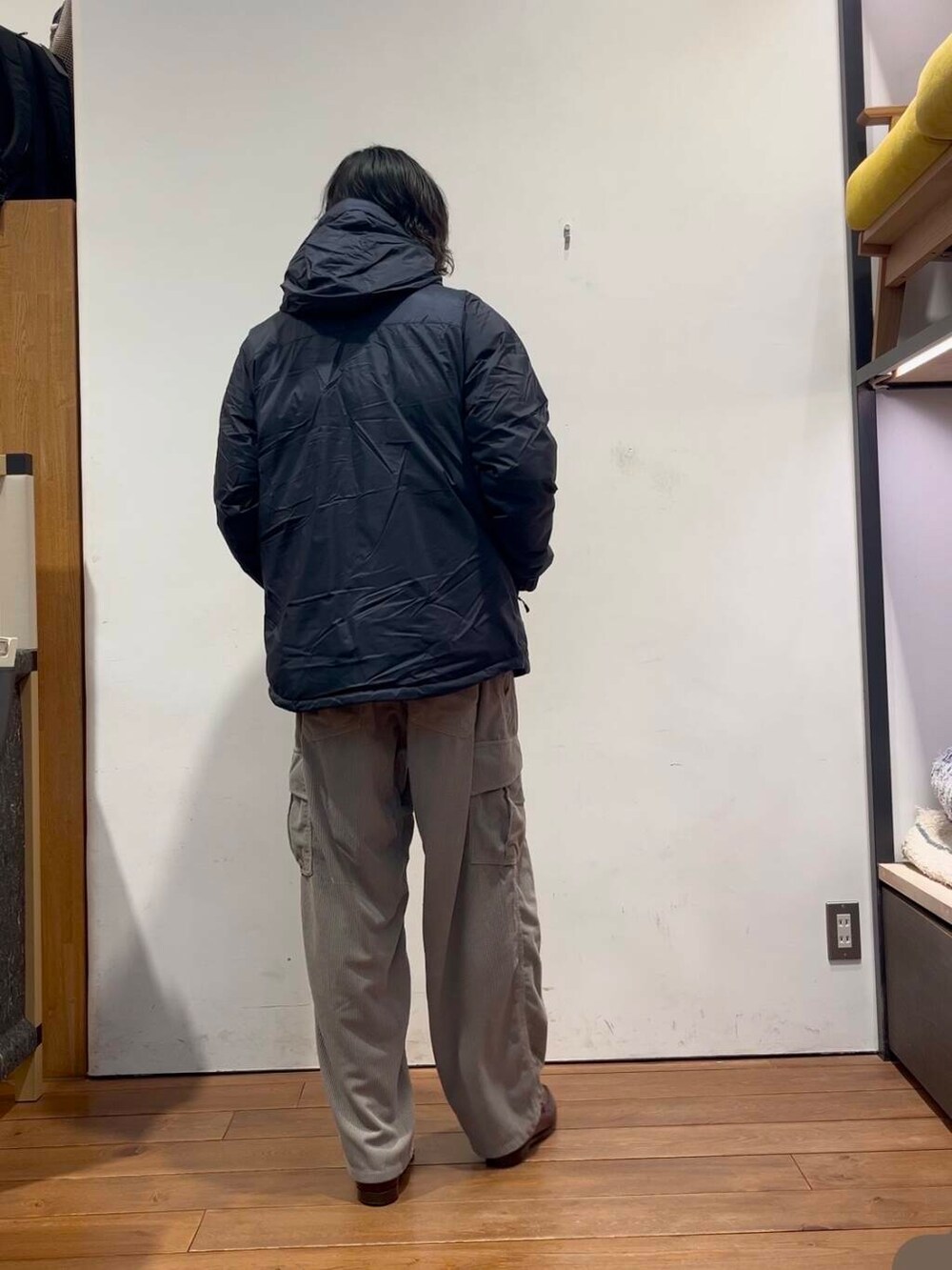 ブルー系のダウンジャケット/コート、ブルー系のニット/セーター、グレー系のその他パンツを着用したメンズの冬コーディネートの2枚目の写真