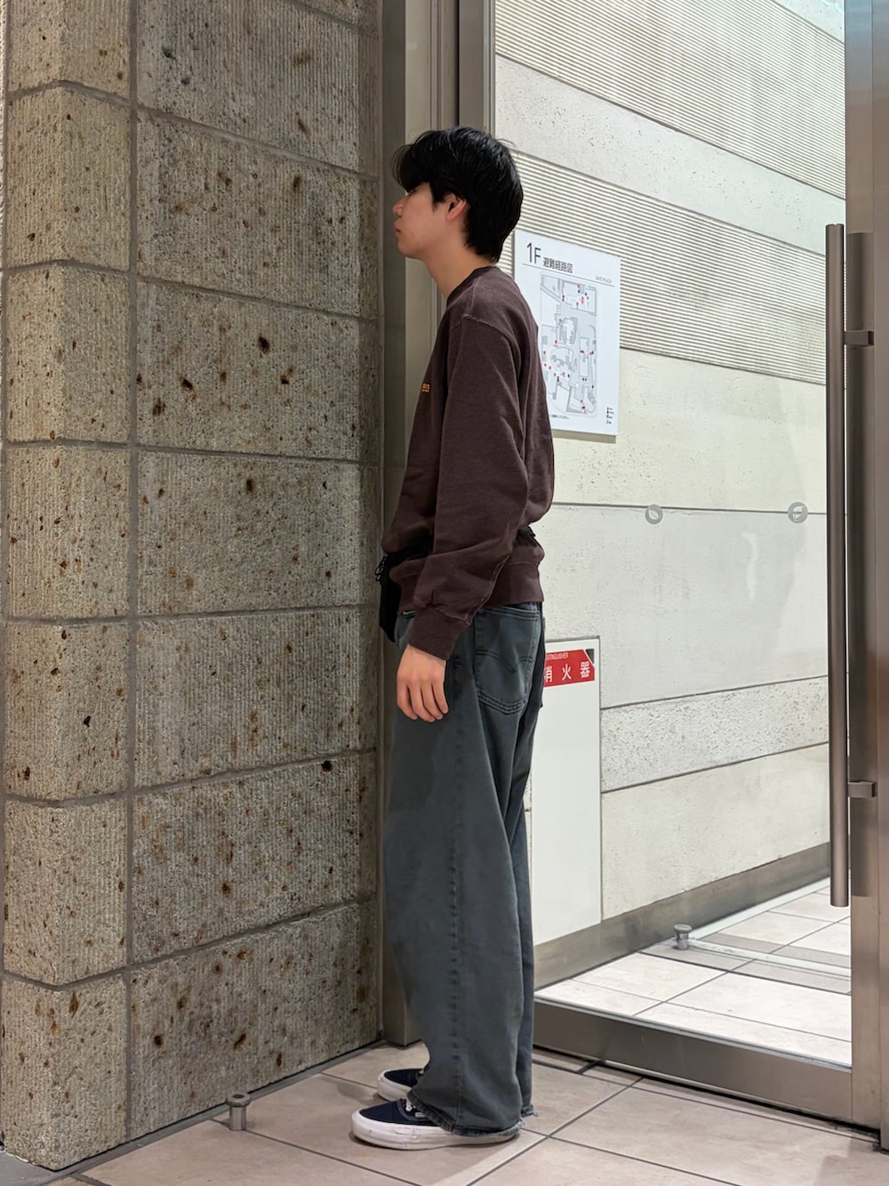 ブラック系のボディバッグ/ウエストポーチ、ブルー系のデニムパンツ、ブラウン系のスウェットを着用したメンズの秋コーディネートの3枚目の写真