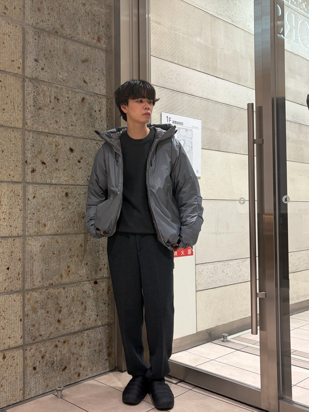 グレー系のダウンジャケット/コート、ブラック系のその他シューズ、ブルー系のその他パンツを着用したメンズの冬コーディネートの2枚目の写真