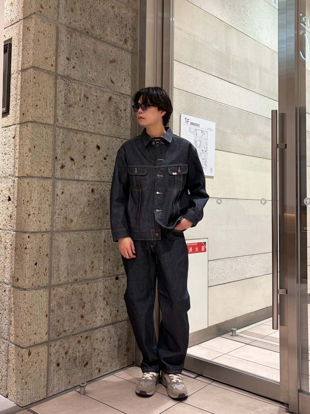 ブルー系のデニムパンツ、ブルー系のデニムジャケット、グレー系のTシャツ/カットソーを着用したメンズの冬コーディネートの2枚目の写真